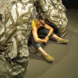 Lena sitting on the floor inside Lung Root sculpture